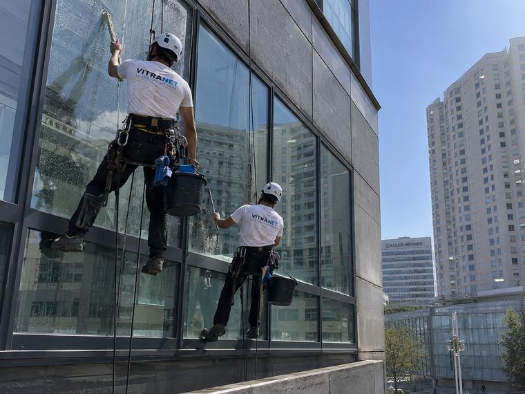 Deux cordistes VITRANET traitant le mur-rideau d'un immeuble de bureaux