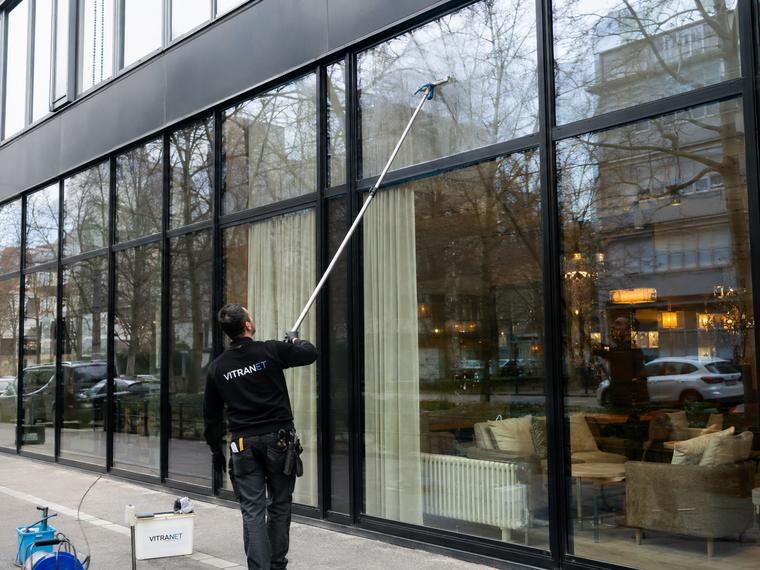 Entretien d'une façade vitrée à la perche télescopique depuis le sol